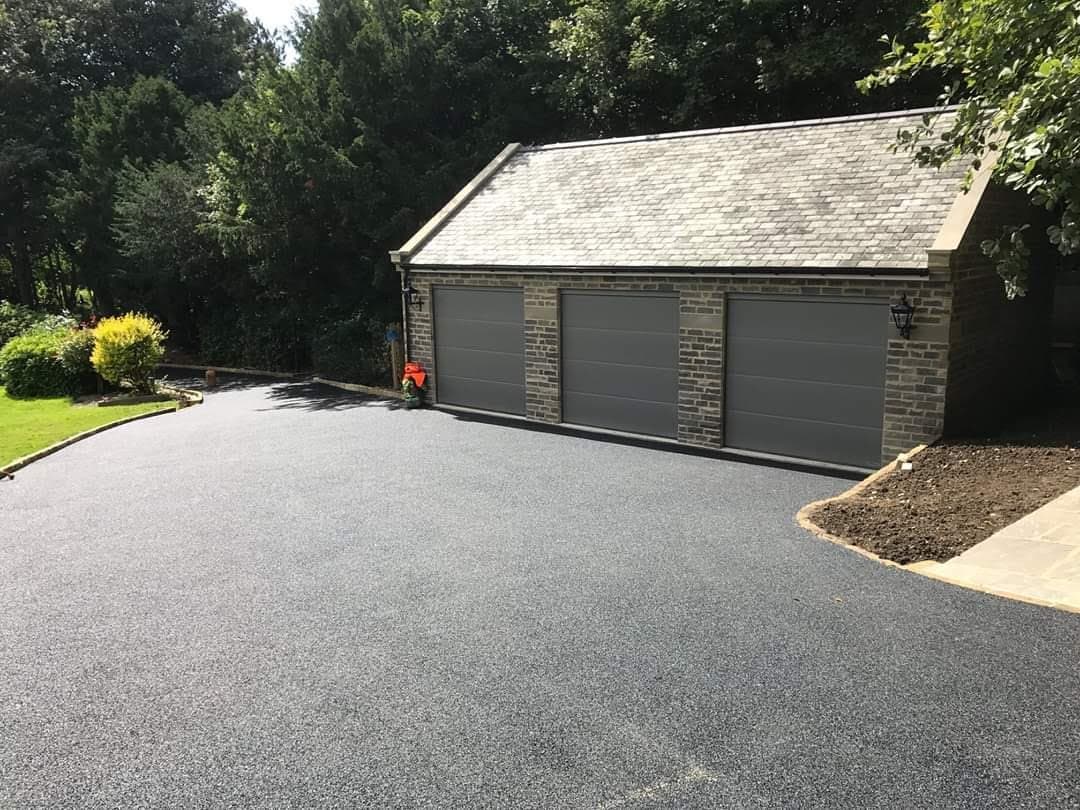 Stone-built triple garage with a slate roof and a newly laid driveway